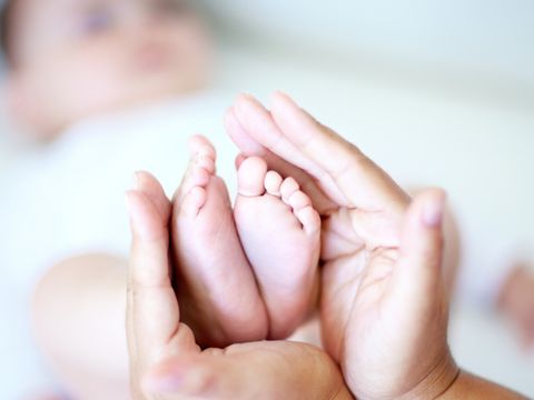 Babyfüße in Frauenhände