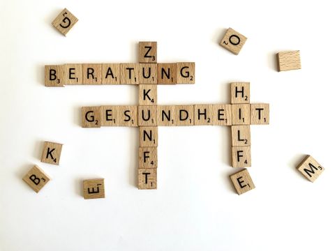 Scrabble-Buchstaben bilden die Worte Beratung, Zukunft, Hilfe und Gesundheit