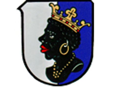 Schild mit den Farben weiß und blau auf dem im Vordergrund eine schwarze Büste einer Frau mit einer goldenen Krone auf dem Kopf