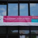 Bildvergrößerung: Eingang zum Konferenzgebäude mit Banner