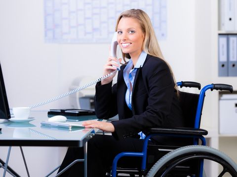 Eine Frau im Rollstuhl an ihrem Arbeitsplatz