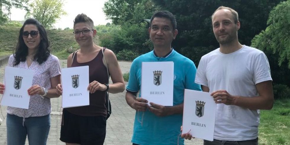 Vier Ehrenamtliche zeigen ihre Urkunden des Bezirksamts Treptow-Köpenick