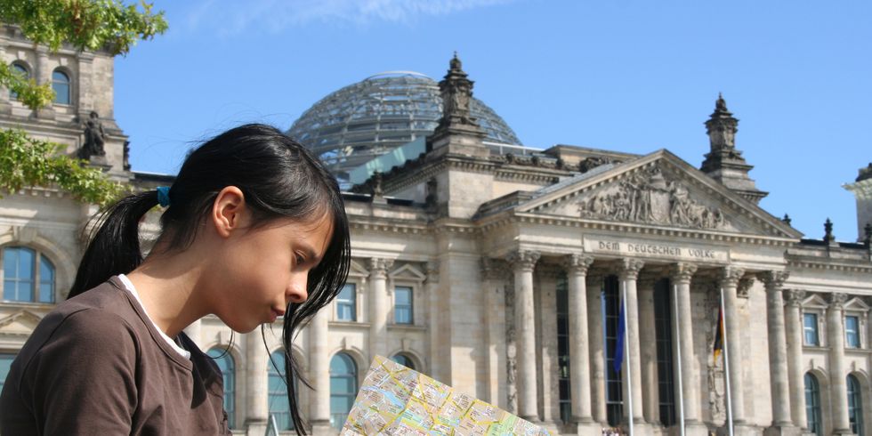Mädchen mit Stadtplan vor dem Reichstagsgebäude