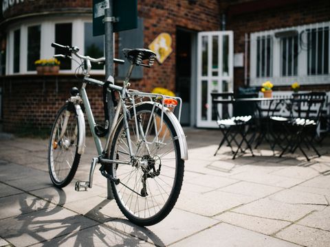 Fahrrad lehnt an einem Schild im Biergarten