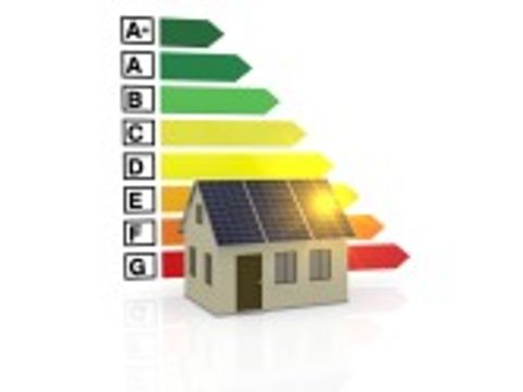 Energie-Effizienz-Maßstab hinter einem Haus mit einer Photovoltarikanlage