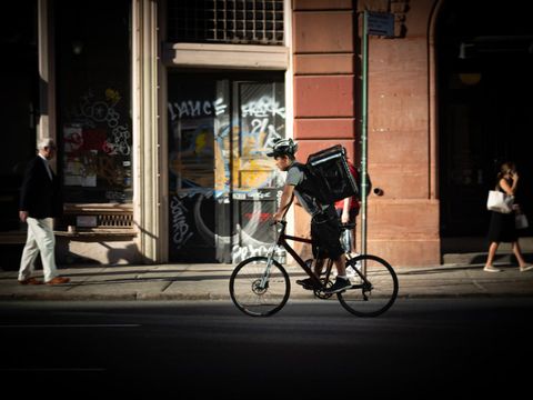 Fahrrad-Kurier eines Zustelldienstes beim Fahren auf der Straße