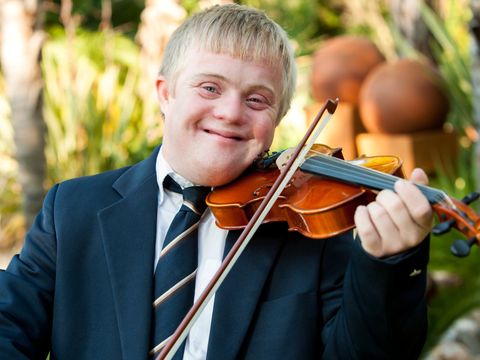 Ein junger Mann mit Downsyndrom spielt Violine