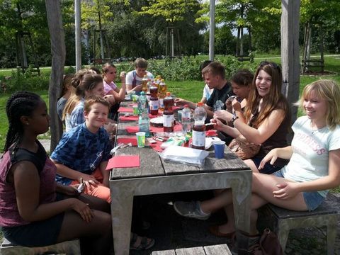 Bildvergrößerung: Jugendliche sitzen in der Natur am Frühstückstisch