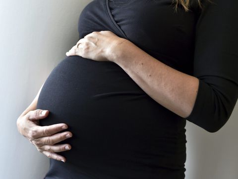 Eine schwangere Frau hält sich den Bauch