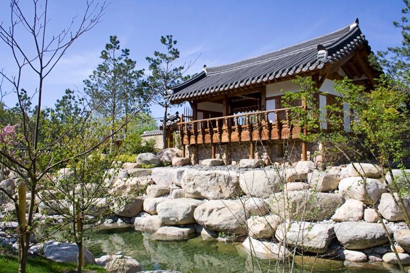 ein Ausschnitt aus dem Erholungspark Marzahn mit einem Gebäude im chinesischen Stil und einem kleinen Bach umrandet mit weißsen Steinen