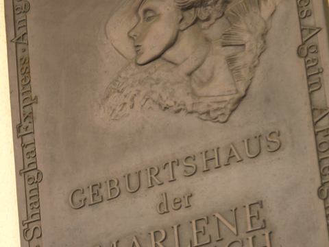 Zu sehen ist die Gedenktafel am Geburtshaus von Marelene Dietrich in der Leber Straße auf der Roten Insel im Schöneberger Ortsteil