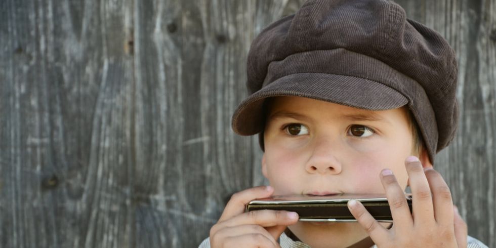 Junge spielt auf der Mundharmonika
