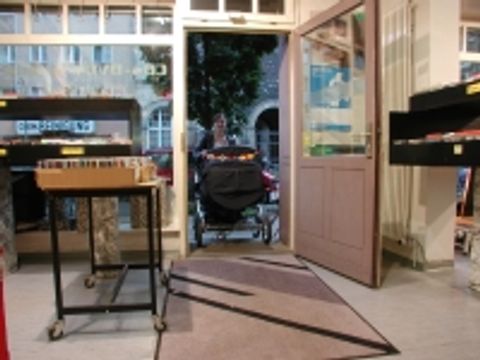 Bildvergrößerung: Kinderwagen wird durch die ausreichend breite Tür eines Ladengschäftes geschoben