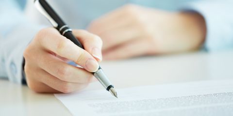 Ein Mann schreibt auf einem Blatt Papier