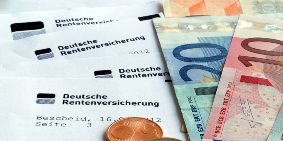Münzen und Geldscheine liegen auf einem Bescheid der Deutschen Rentenversicherung