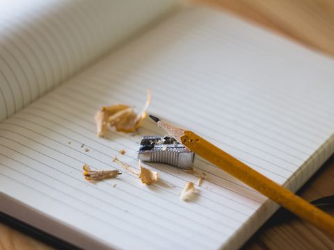 Bleistift mit Bleianspitzer auf einem Notizbuch