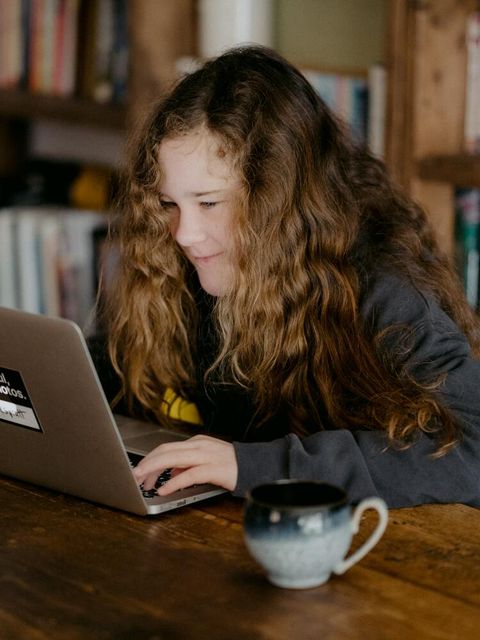 Ein Mädchen sitzt an einem Laptop