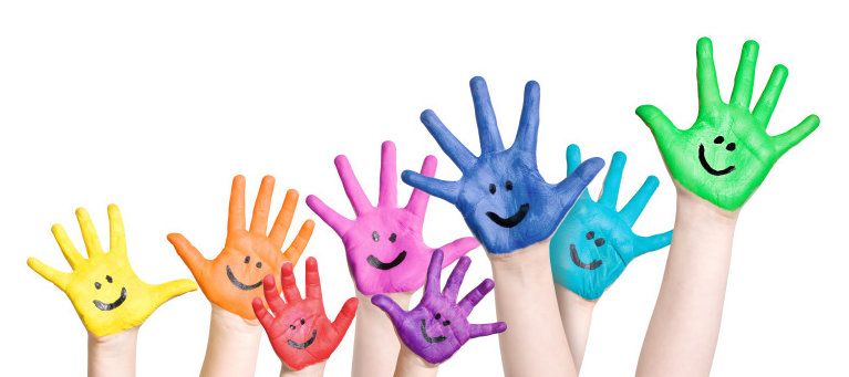 lachende Kinderhände in Regenbogenfarben