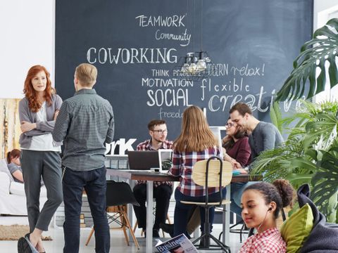 Junge Unternehmerinnen und Unternehmer in Gesprächen in einem Coworking-Space