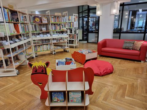 rote Möbel vor Bücherregalen