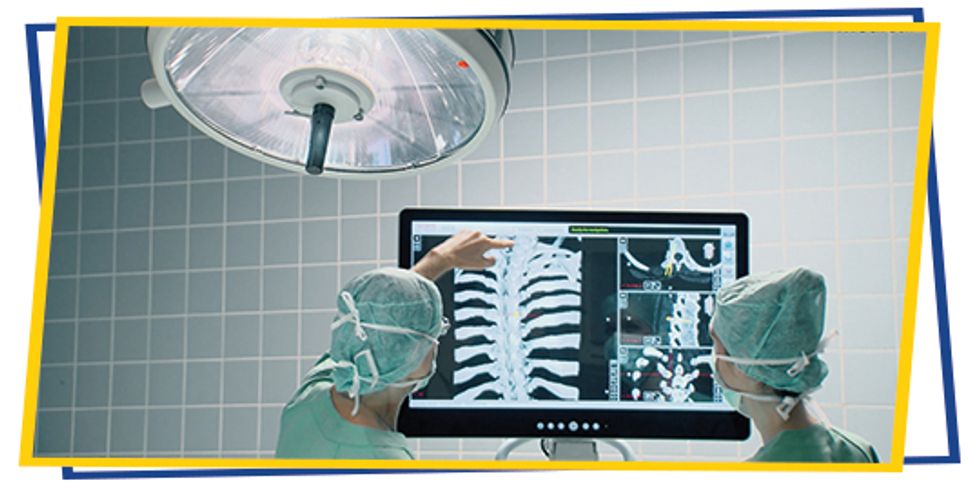 Zwei Chirurgen schauen auf digital erstelltes "Röntgenbild".