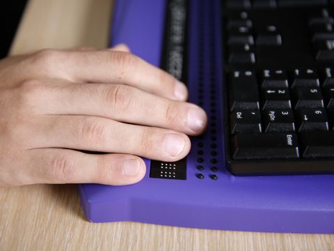 Person nutzt eine Computer-Tastatur mit Braille-Zeile