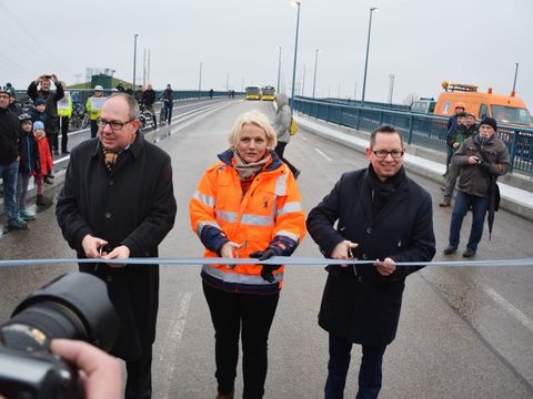 Bildvergrößerung: Oliver Igel schneidet das Band zur Einweihung der Brücke mit Senatorin Günther und Staatssekretär Bunde durch