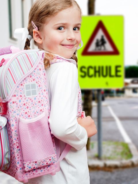 Kind vor "Schule"-Schild