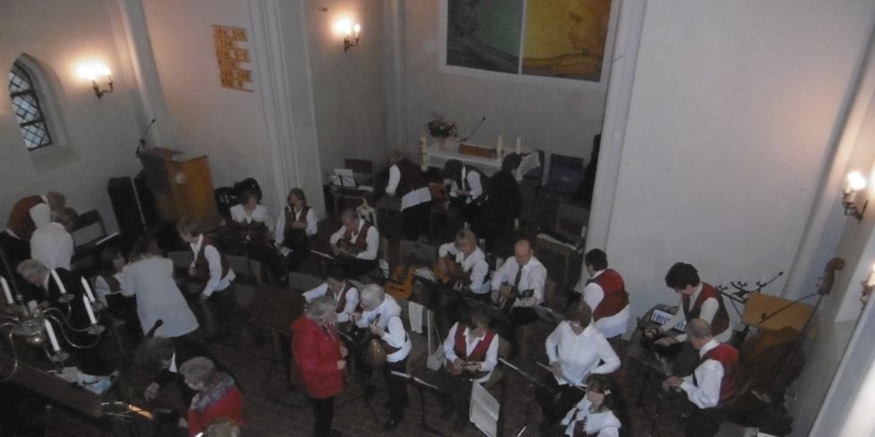 Musiker des Volksinstrumentenorchesters in einer Gruppe