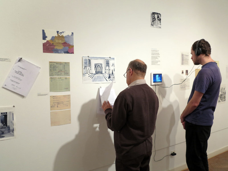 Besucher vor einer Collageartig arangierten Ausstellungswand