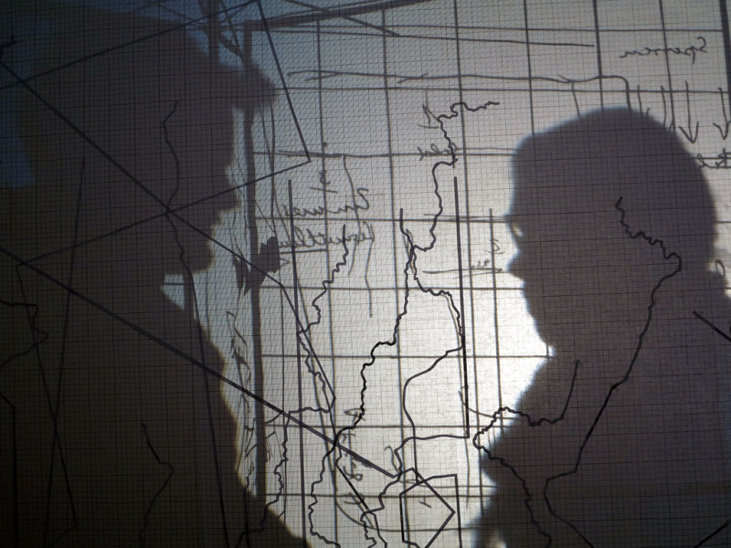 Schatten von Birgit Auf der Lauer & Caspar Paul, geworfen auf die Leinwand mit Landkarten