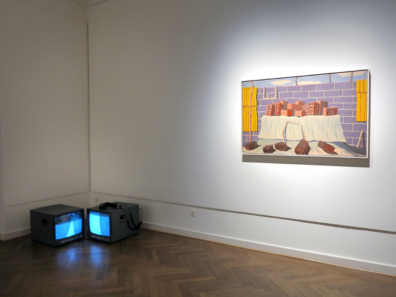 Links auf dem Boden ist eine Videoinstallation zu sehen: am Boden stehen zwei Monitore im 90 Grad Winkel zueinander, rechts an der Wand ist eine großformatige Malerei an der Wand angebracht.