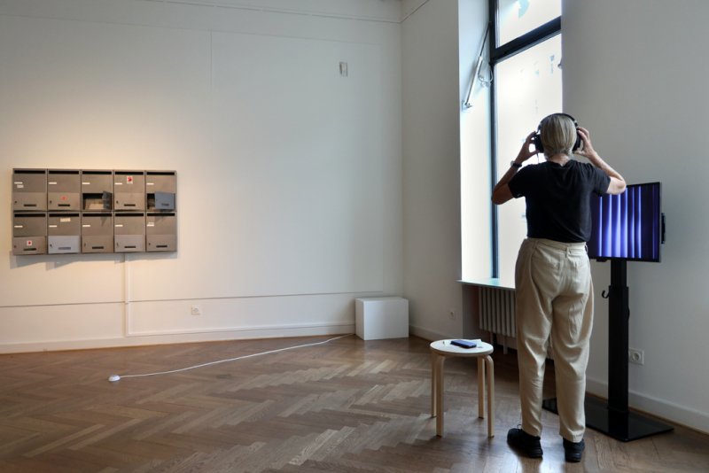 eine Besucherin hört und sieht sich das Werk "Torpor - Guest Room" von Chelsea Leventhal an