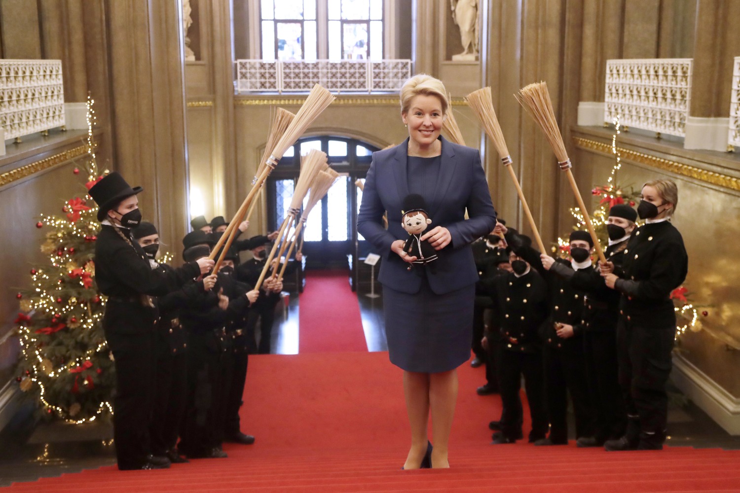 Die neue Regierende Bürgermeisterin von Berlin, Franziska Giffey, wird von Schornsteinfeger:innen auf der Treppe im Foyer des Hauptportals im Roten Rathaus begrüßt 