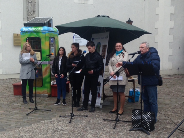 6 Teilnehmende bei der Bücheboxx-Eröffnung in Stettin während einer musikalischen Darbietung vor der Bücherboxx
