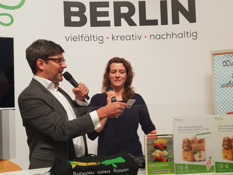 Senator Dr. Dirk Behrendt mit einer Mitarbeiterin der Verbraucherzentrale Berlin beim Kühlschrankquiz