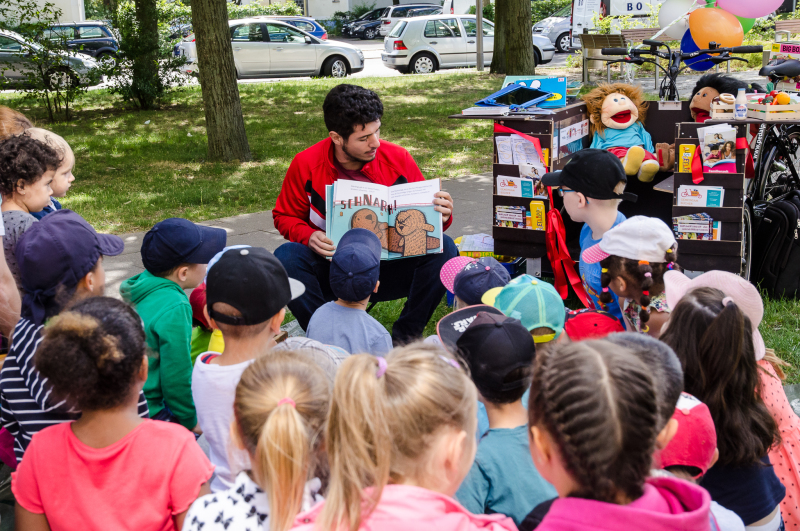 Emre Basbolat liest den Kindern aus einem Buch vor
