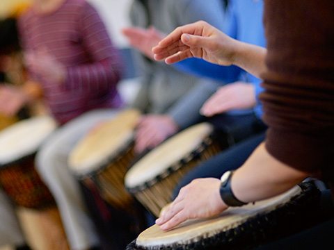 Nahaufnahme von Händen die auf Djembe trommeln