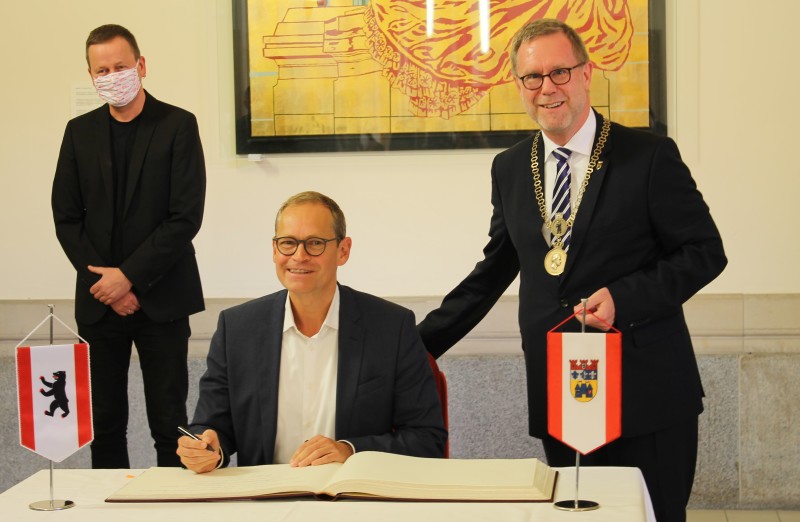 Michael Müller, der Regierende Bürgermeister von Berlin trägt sich ins Goldene Buch des Bezirks Charlottenburg-Wilmersdorf ein. Rechts: Bezirksbürgermeister Reinhard Naumann, links: Kultursenator Klaus Lederer