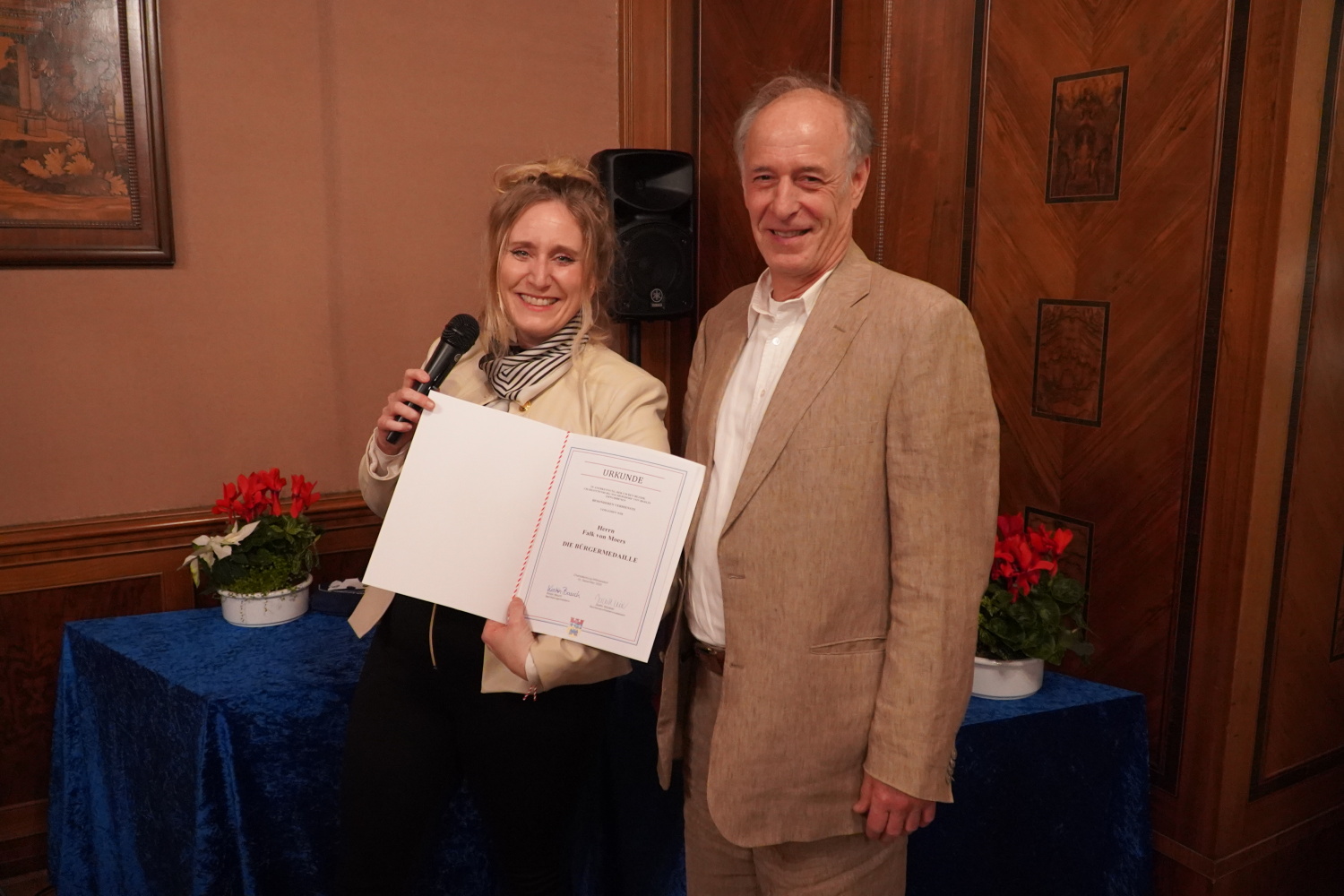 Bezirksbürgermeisterin Kirstin Bauch mit Preisträger Falk von Moers bei der Verleihung der Bürgermedaille 2025