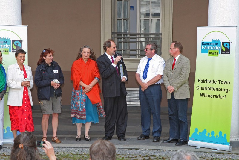 *Entgegennahme der verliehenen Auszeichnung "Fairtrade Town"* Im Innenhof des Rathaus Wilmersdorf, nahm unsere Bezirksbürgermeisterin Monika Thiemen die Auszeichnung "Fairtrade Town" von Transfair im Rahmen einer Veranstaltung entgegen gemeinsam mit der Steuerungsgruppe und Mitgliedern des Bezirksamts Frau Schmiedhofer, Herrn Gröhler, Herrn Krüger.