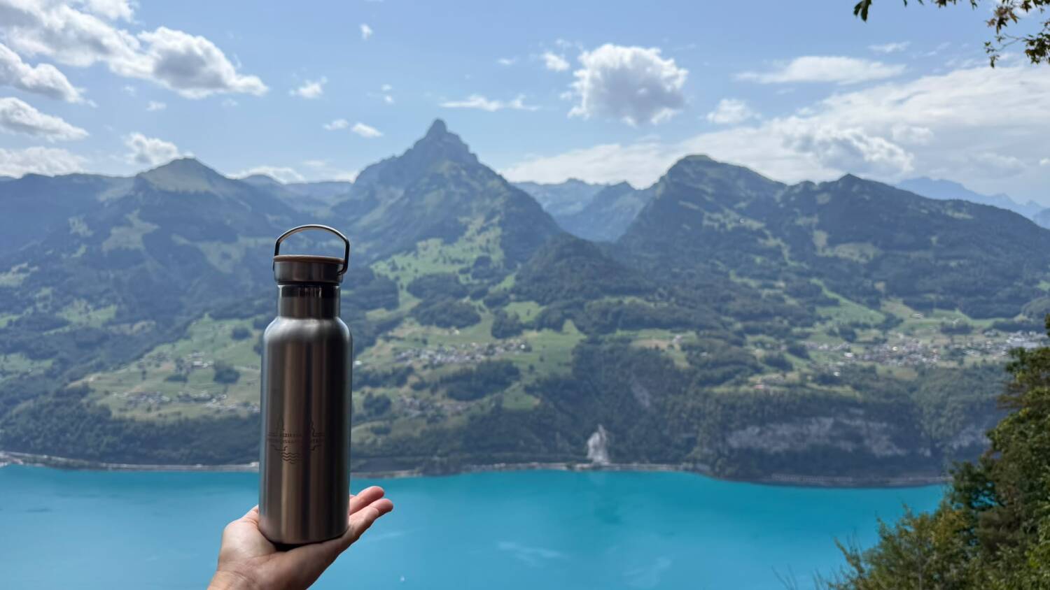 Flasche mit Gravur vor Bergpanorama