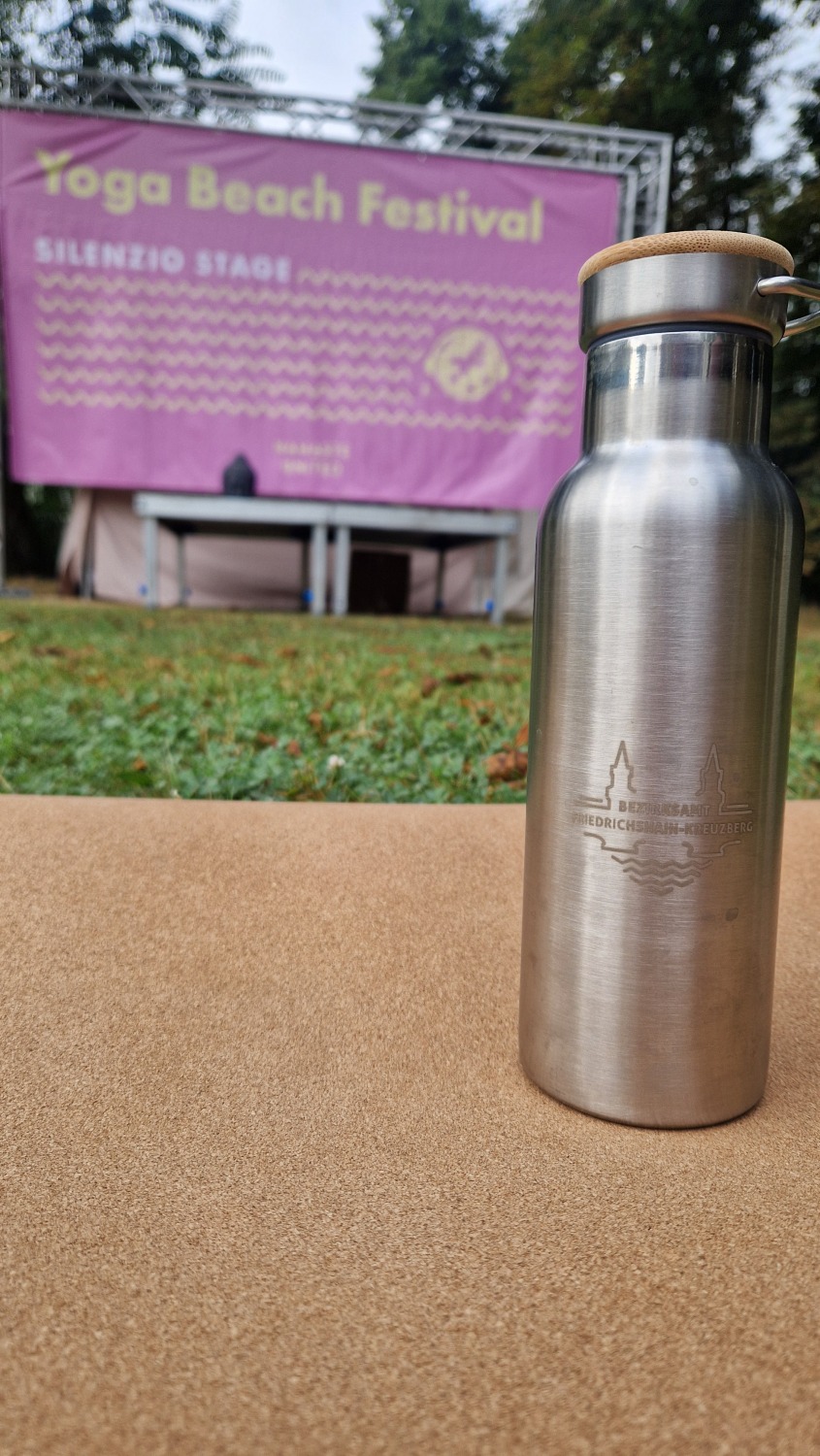 Flasche vor dem Banner eines Yoga-Retreats