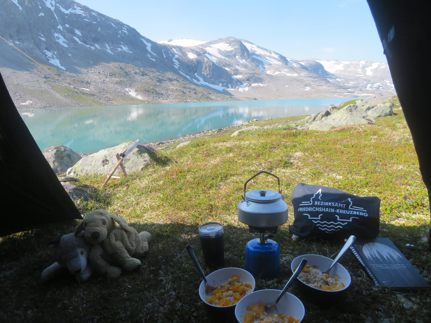beutel und thermobecher neben Campingszene vor bergpanorama in skandinavien