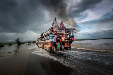 People cross a flooded section of the Pan-American Highway in a bus in Chinandega.Heavy rains have caused flooding in this area October 14, 2011./Oswaldo Rivas