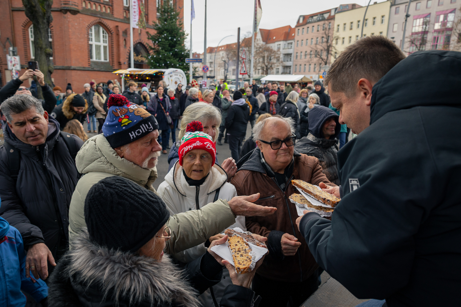 30. Lichtenberger Lichtermarkt, 30. November 2025: Bezirksbürgermeister Martin Schaefer verteilt Stolle an Publikum