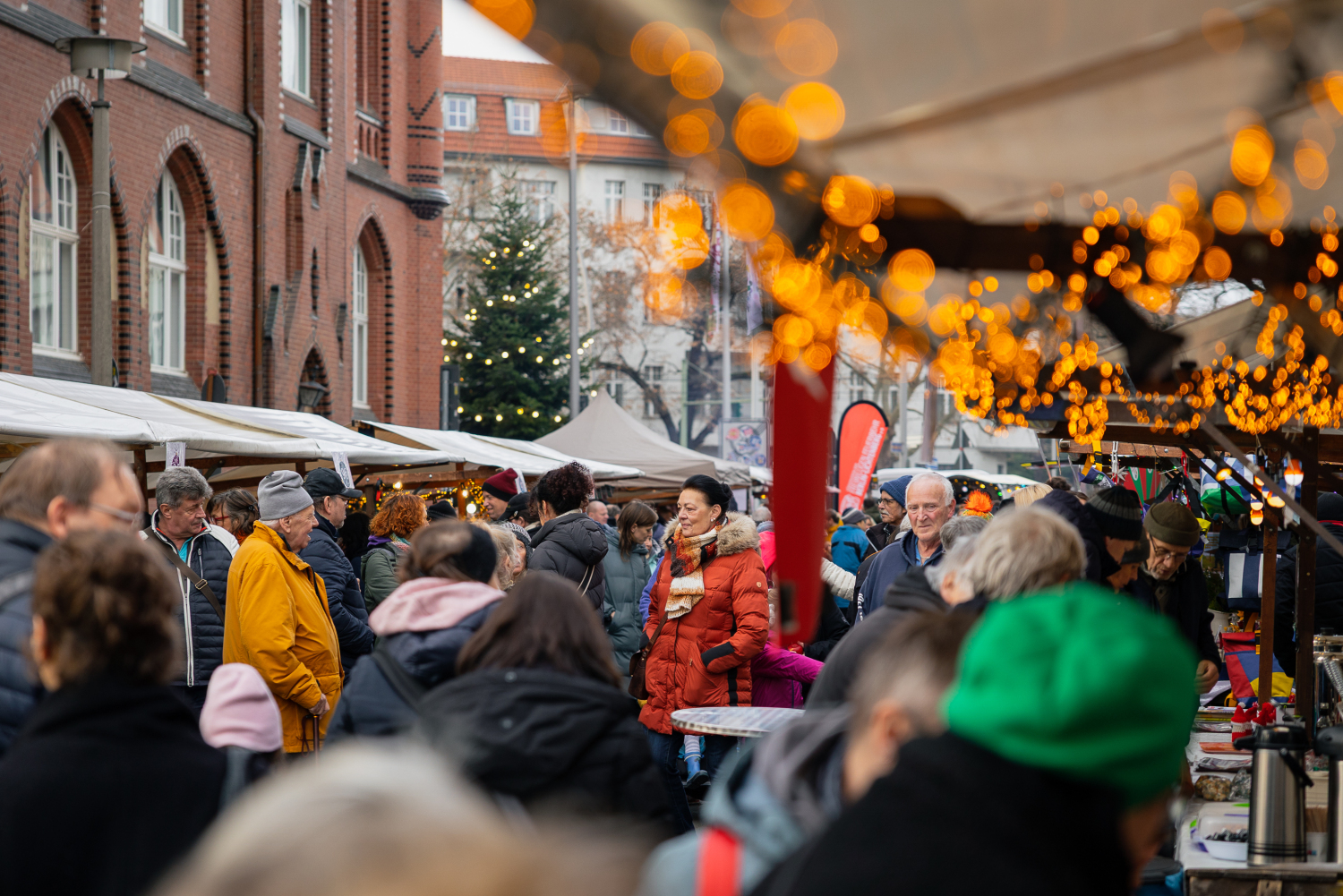 30. Lichtenberger Lichtermarkt, 30. November 2025: Blick durch die Gasse der Marktstände und Menschenmenge, viele Lichter
