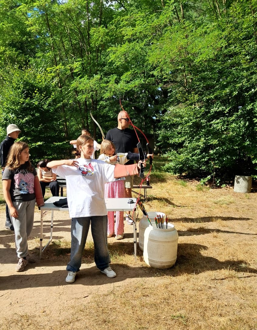 Teilnehmer:innen beim Bogenschießen