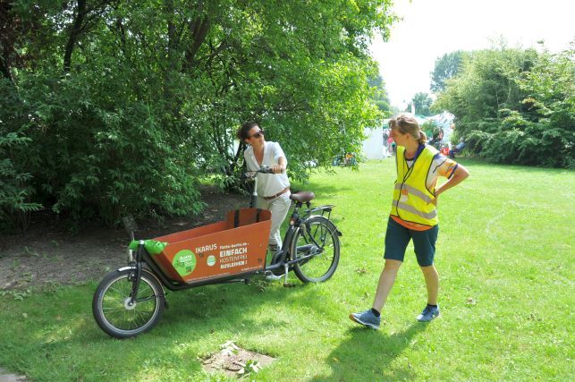 Bezirksstadträtin Nadja Zivkovic fährt mit dem Lastenfahrrad über das Gelände der Gärten der Welt