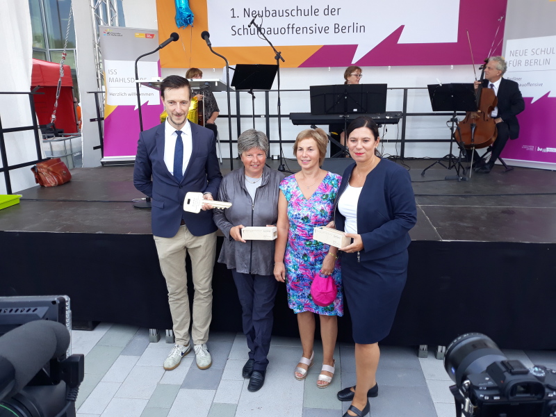 Gordon Lemm, Senatorin Katrin Lompscher, Schulleiterin Sibylle Fricke und Senatorin Sandra Scheeres mit dem Schlüssel und zwei Mini-Holz-Modulen